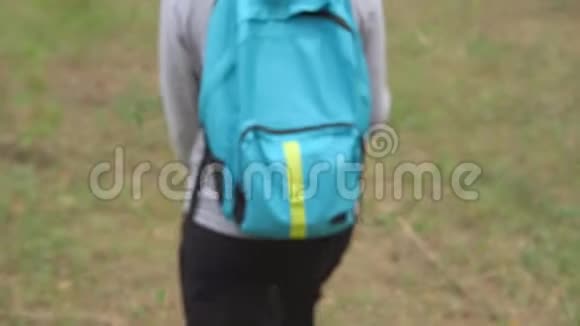 带着背包的女人穿过森林从后面看视频的预览图