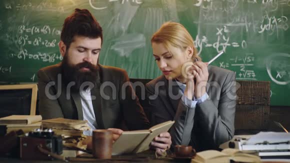 商人在学校办公室和女秘书一起工作长胡子的男人和性感的女人读书一对打字机视频的预览图