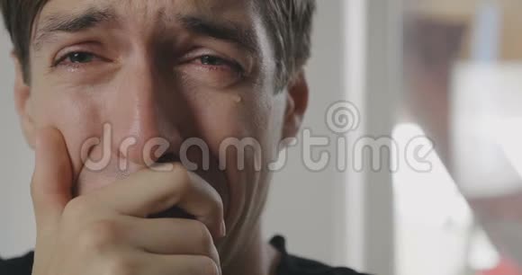 闭上悲伤的人的眼睛含着泪水哭泣他脸颊上的泪珠视频的预览图