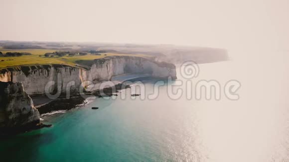在日落时分沿着美丽的蔚蓝海岸线飞行的无人机在阳光明媚的诺曼底埃特雷特和史诗般的白色粉笔悬崖视频的预览图