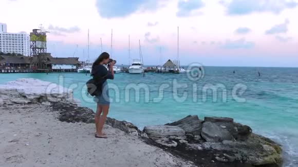 在坎昆的加勒比海海滩上女孩用相机拍照视频的预览图