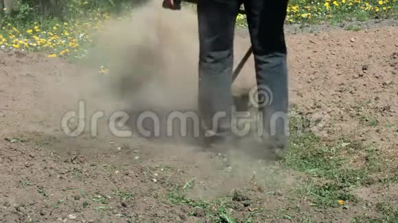 工人用细绳草坪修剪器在土壤田之间割草视频的预览图
