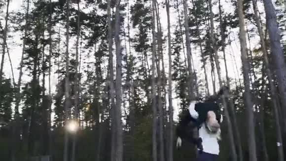 在美丽的松树背景下异族夫妇在森林里跳舞年轻的跳舞情侣相爱他是视频的预览图