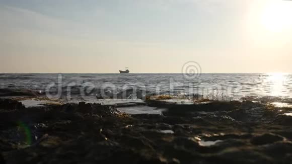 小货船在晨海边航行海浪覆盖石滩视频的预览图