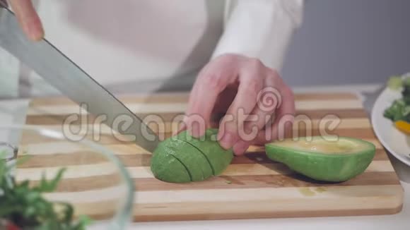 一个女人正在切熟的鳄梨在切割板上放着一把菜刀视频的预览图
