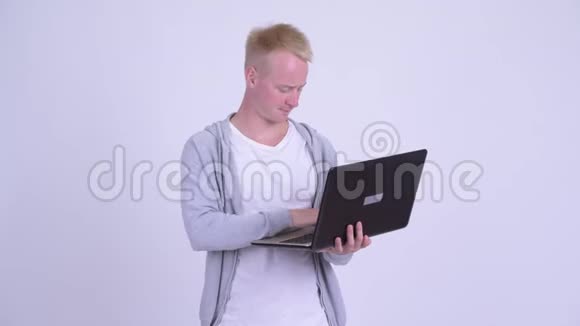 快乐的年轻金发帅哥思考笔记本电脑视频的预览图