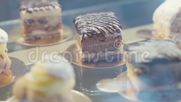 玻璃展柜内的特写ECLair和巧克力蛋糕视频的预览图