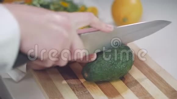 一个女人用刀把鳄梨切成两半视频的预览图
