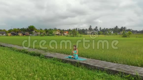 一位年轻女子用巴厘岛的方式为穆拉哈拉查克拉做冥想的慢镜头视频的预览图