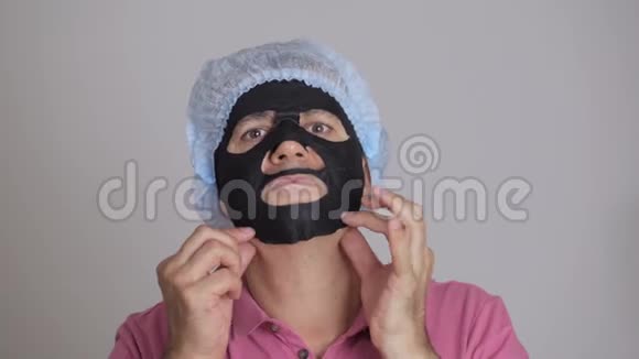 厌恶的男人从他的脸上摘下一个恢复活力的黑色化妆面具把它扔到一边视频的预览图