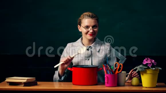 一个戴眼镜的女孩在一个绿色的学生板的背景上把蜡笔和钢笔扔进罐子里概念视频的预览图