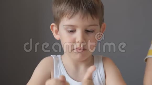小男孩在面团的手掌中滚动伸展它使它变平视频的预览图