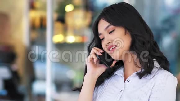 亚洲女商人用智能手机聊天时的笑容视频的预览图