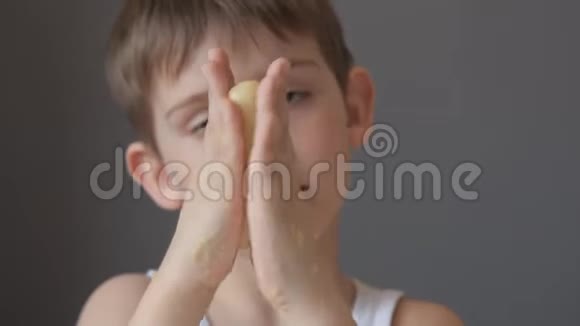 小男孩在面团的手掌中滚动伸展它使它变平视频的预览图