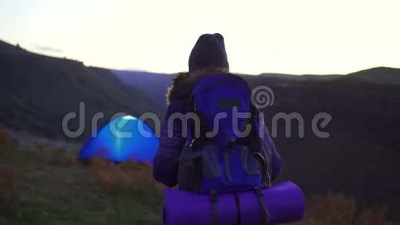 日落时分背着徒步旅行背包的女人回到了帐篷视频的预览图