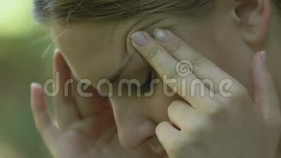 美丽的年轻女性患有严重的偏头痛按摩太阳穴视频的预览图