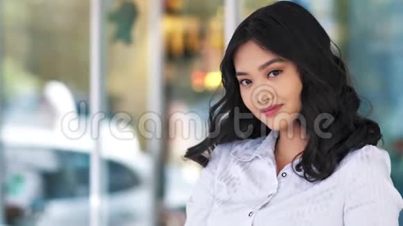 微笑的亚洲年轻商务女性看镜头的中型特写镜头视频的预览图