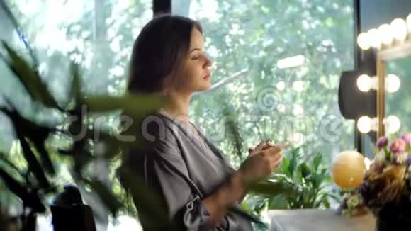 优雅的女人用香水喷洒自己视频的预览图