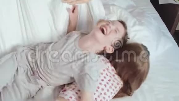 快乐的孩子在父母的床上跳跃视频的预览图