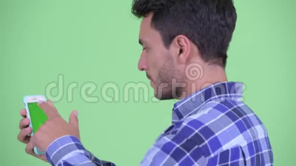 快乐年轻的西班牙裔男子使用电话后景视频的预览图
