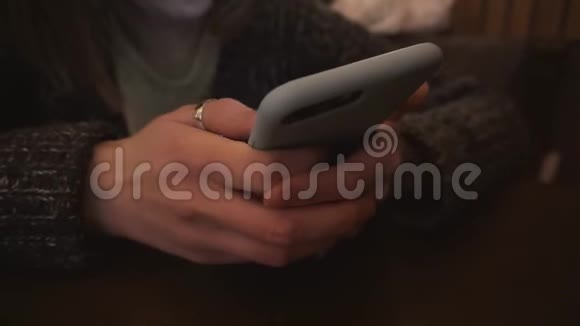 女性的手使用智能手机在木制桌子上与柔软的内部照明视频的预览图