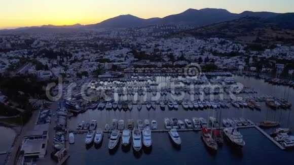 日落时停泊在港口的精英游艇的空中镜头度假小镇博德鲁姆土耳其总体计划视频的预览图