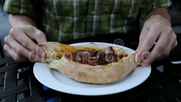 男人正在吃一道格鲁吉亚民族菜卡查普里相机运动他把一块面包撕下来蘸了蘸视频的预览图