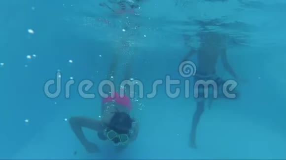 两个快乐的微笑水下女孩和男孩在游泳池游泳视频的预览图