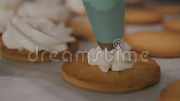 准备棉花糖带有糖果袋的厨师在糕点纸上将奶油挤压成饼干视频的预览图