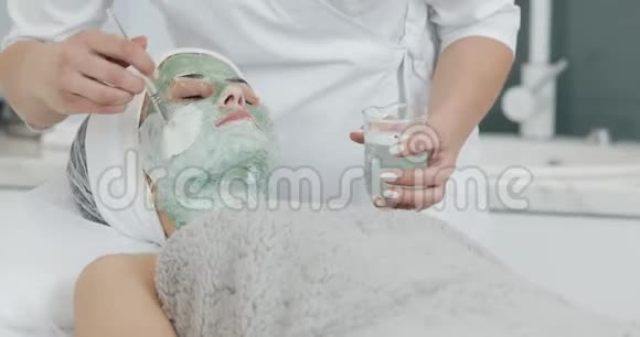 美容师的漂亮女孩做水疗女人被洗掉了绿色的面具视频的预览图