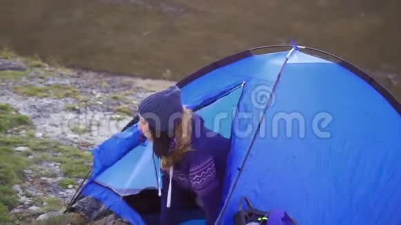 野营女孩从帐篷里出来向远处望去视频的预览图