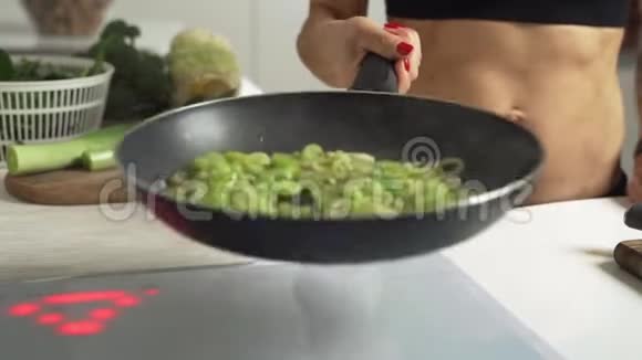特写的烹饪炒洋葱和芹菜把它们放入热煎锅慢动作视频的预览图