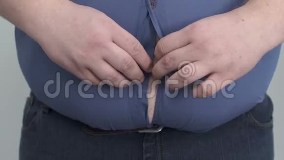 一个胖子在大肚子上拼命扣衬衫肥胖视频的预览图