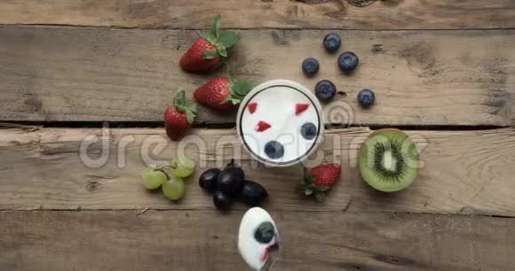 手拿酸奶用勺子盛杯视频的预览图
