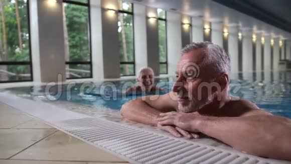 可爱的老夫妇在温泉酒店的游泳池放松视频的预览图
