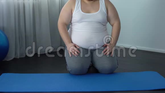 肥胖男性试图坐在莲花的位置练习瑜伽健康的生活方式视频的预览图