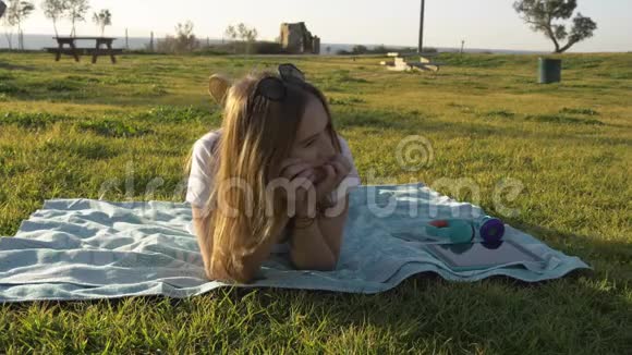 心情好的年轻女子躺在公园里做梦视频的预览图