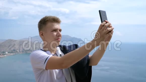 一个男人在山上和天空的背景下自拍的肖像视频的预览图