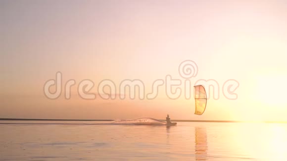 慢镜头拍摄一个人在日出时眩目的阳光下从事风筝冲浪视频的预览图