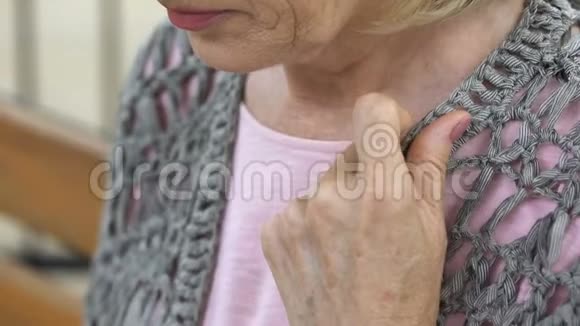 老年女性双手扣上针织开衫坐在长凳上退休视频的预览图