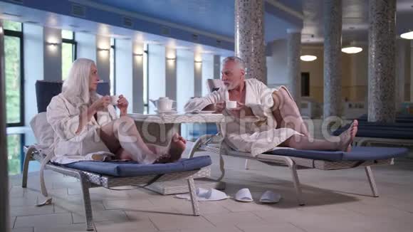 在游泳池附近的酒店享受休闲的老年夫妇视频的预览图
