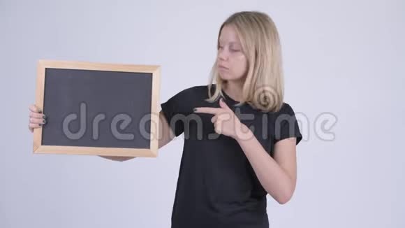 年轻严肃的金发女郎拿着黑板竖起大拇指视频的预览图