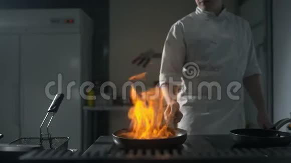 厨师在厨房的热锅上缓慢地点燃火焰厨房里大明火锅着火做饭视频的预览图