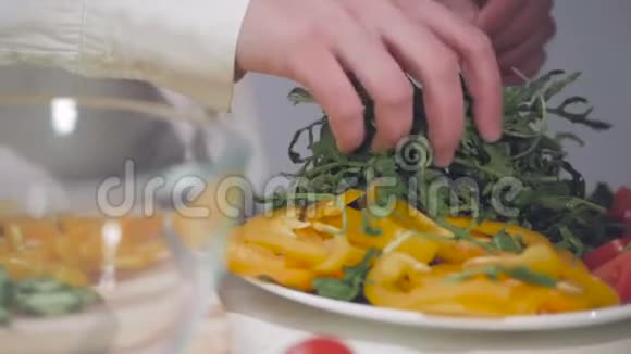 特写一个女人的手折叠蔬菜和鲁科拉叶成一个玻璃碗视频的预览图