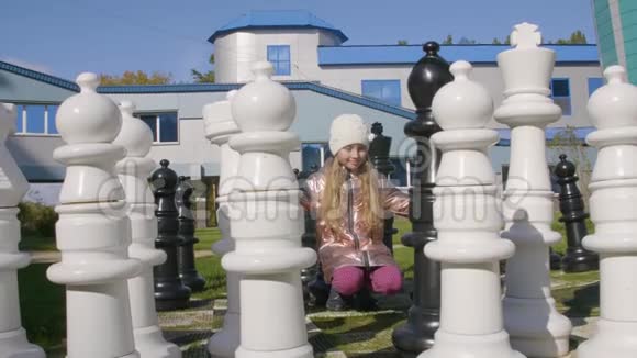 在户外摆着黑白象棋的小女孩视频的预览图