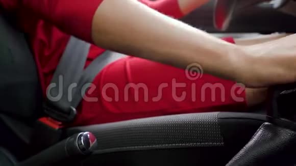 一位身着红色礼服的女士坐在车内在开车前检查车内变速箱视频的预览图