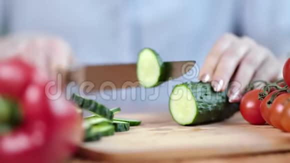 用刀子将新鲜的有机黄瓜切在木板上视频的预览图