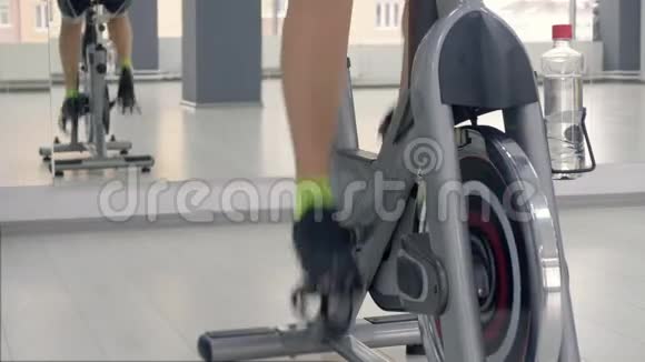 在自行车课上女腿在自行车机上旋转踏板视频的预览图