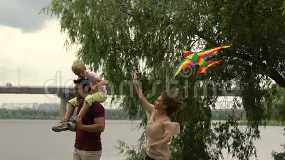 母亲和儿子一起放风筝坐在父亲的肩上幸福视频的预览图