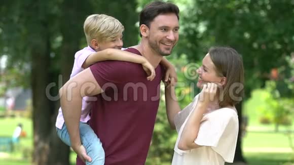 父亲给儿子搭便车幸福的家庭在公园度过了美好的时光视频的预览图